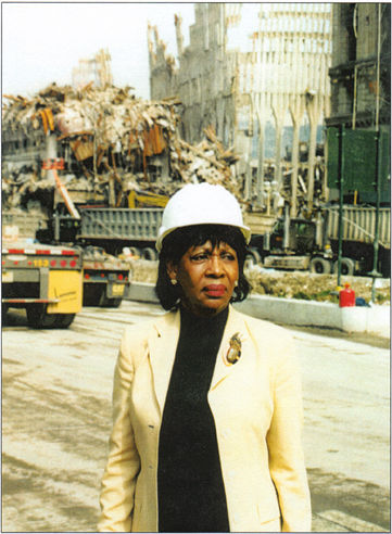  Photo of Congresswoman Maxine Waters wearing a hardhat in front of trucks hauling debris from the World Trade Center rubble.